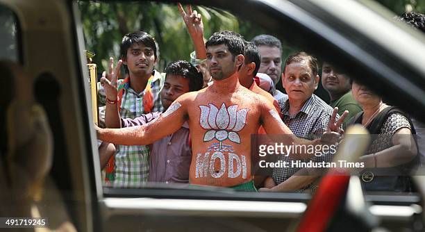 Supporters and workers celebrate during the BJP parliament board meeting, after party's landslide victory in Lok Sabha election, at BJP Headquarter...