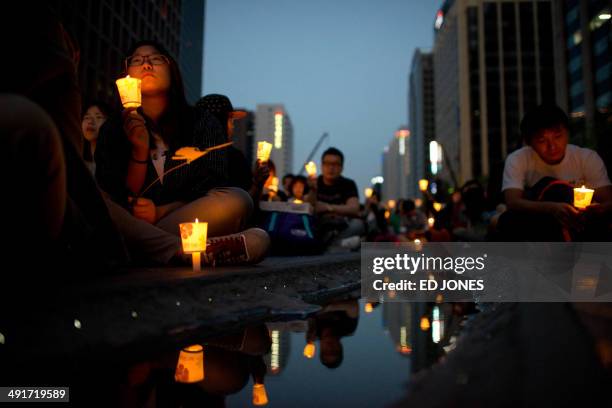 Participants attend a candle-lit vigil for victims of the Sewol ferry during which they also denounced the government response to the disaster, in...