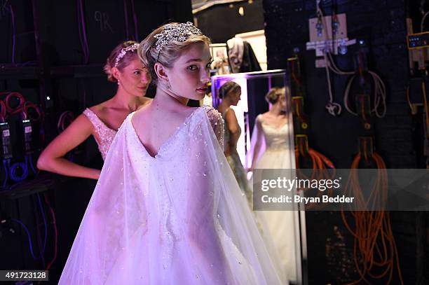 Models prepare backstage during 2016 Alfred Angelo Disney Fairy Tale Weddings Bridal Collection fashion show debut at New Amsterdam Theatre on...