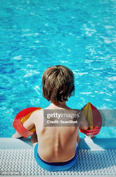 child sitting on poolside - armrest stock pictures, royalty-free photos & images
