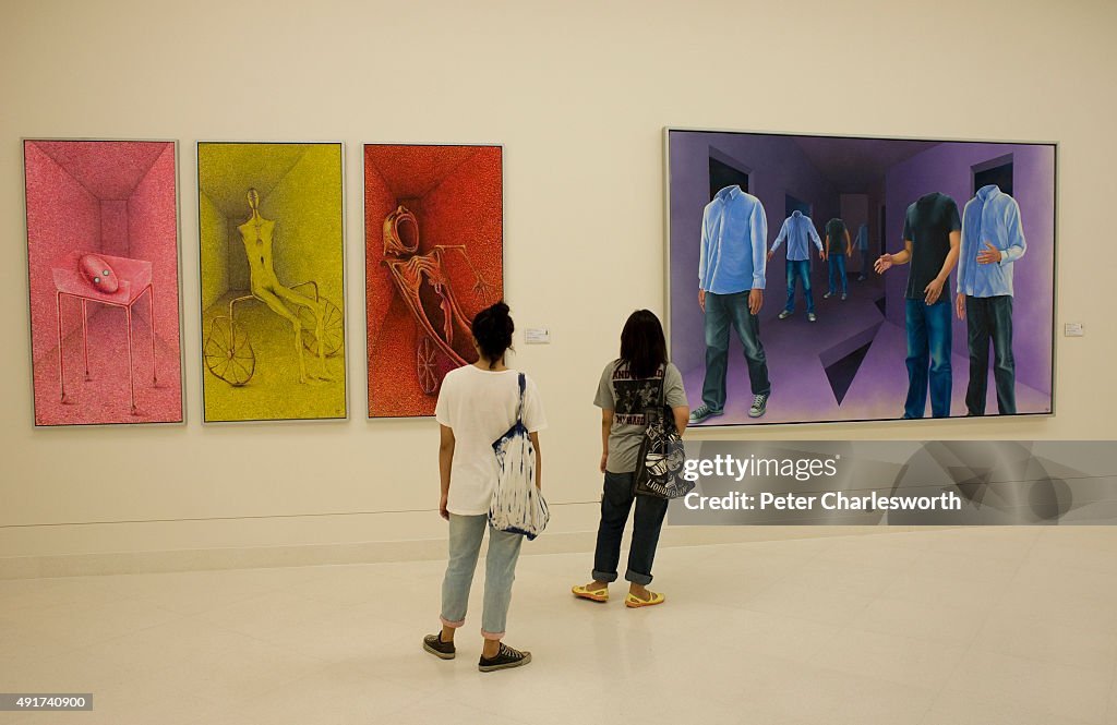 Visitors look at paintings inside the six-story Museum of...