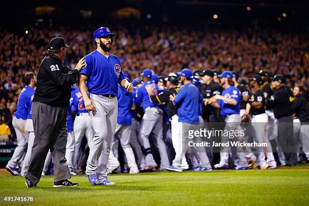 Jake Arrieta of the Chicago Cubs walks off the field with umpire Hunter Wendelstedt after being hit by a pitch thrown by Tony Watson of the...