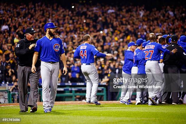 Jake Arrieta of the Chicago Cubs walks off the field with umpire Hunter Wendelstedt after being hit by a pitch thrown by Tony Watson of the...