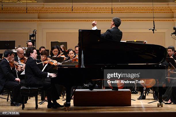 Pianist Evgeny Kissin, Conductor Alan Gilbert and the New York Philharmonic perform on stage during the Carnegie Hall 125th season opening night gala...