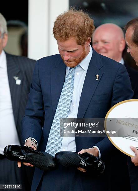 Prince Harry is presented with a pair of rugby boots with his name stitched into them as he visits Paignton Rugby Club to present them with an RFU,...