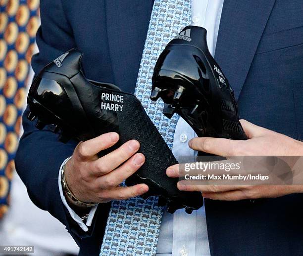 Prince Harry is presented with a pair of rugby boots with his name stitched into them as he visits Paignton Rugby Club to present them with an RFU,...