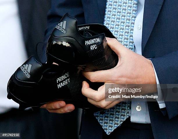 Prince Harry is presented with a pair of rugby boots with his name stitched into them as he visits Paignton Rugby Club to present them with an RFU,...