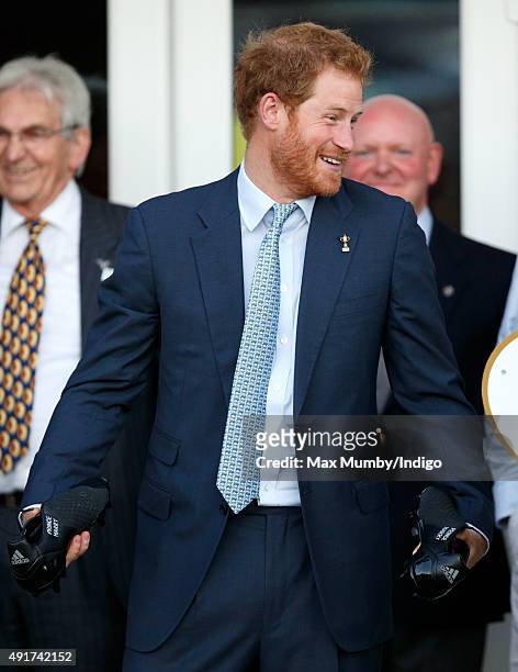 Prince Harry is presented with a pair of rugby boots with his name stitched into them as he visits Paignton Rugby Club to present them with an RFU,...