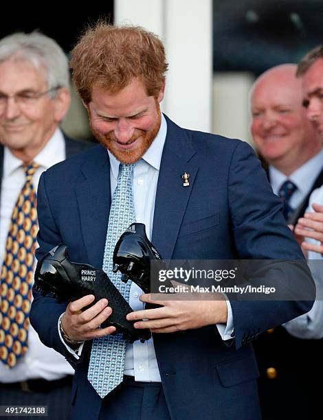 Prince Harry is presented with a pair of rugby boots with his name stitched into them as he visits Paignton Rugby Club to present them with an RFU,...