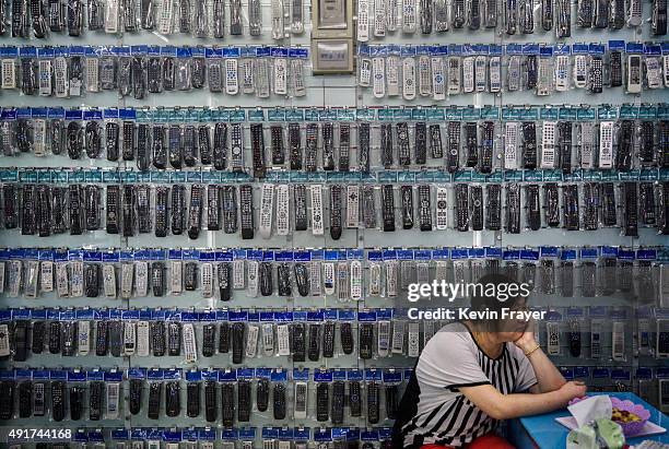 Chinese trader waits for customers at her stall selling wholesale remote controls at the Yiwu International Trade City on September 19, 2015 in Yiwu,...