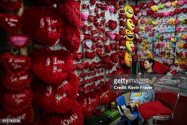 Chinese trader naps as she waits for customers at her stall selling stuffed toys and other items at the Yiwu International Trade City on September...