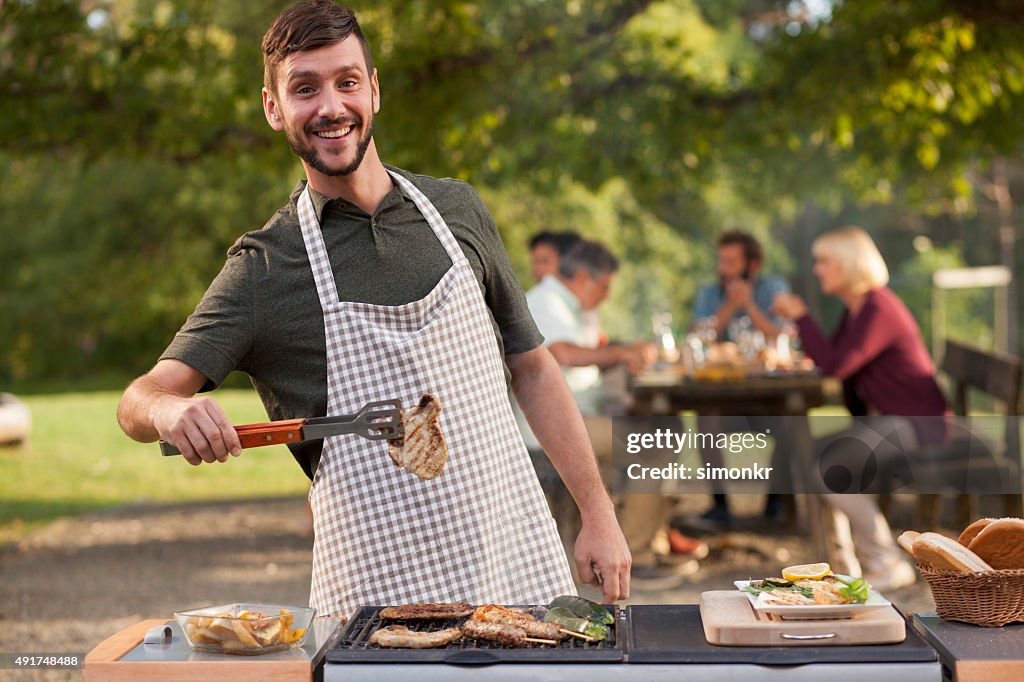 Porträt des Menschen Grillen Fleisch auf barbecue im Freien