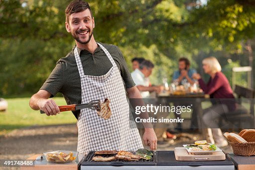 男性のポートレート、屋外グリルでバーベキューの肉 男性のポートレート、屋外グリルでバーベキューの肉