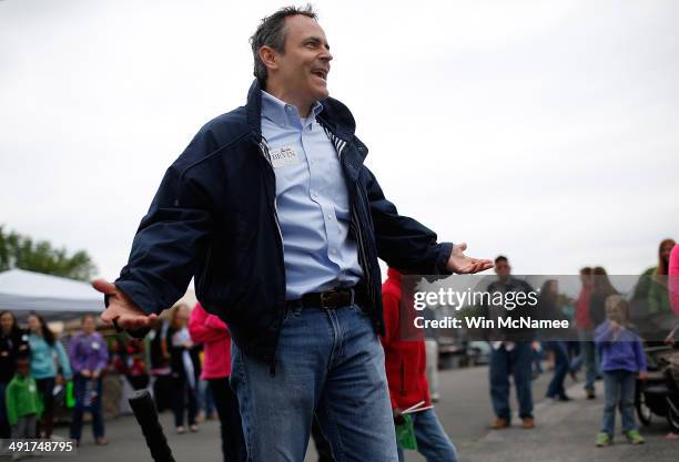 Kentucky Republican senatorial candidate Matt Bevin reacts after ringing the bell on the "High Striker" game at the Fountain Run BBQ Festival while...