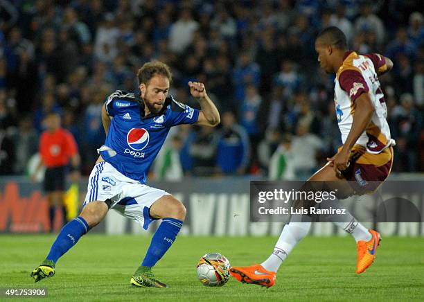 Federico Insua of Millonarios vies for the ball with Davinson Monsalve of Deportes Tolima during a match between Millonarios and Deportes Tolima as...