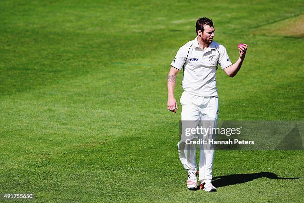 Doug Bracewell looks at the new pink cricket ball during a New Zealand cricket training session at Seddon Park on October 8, 2015 in Hamilton, New...