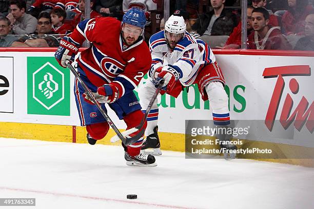 Josh Gorges of the Montreal Canadiens moves the puck in front of Benoit Pouliot of the New York Rangers in the first period in Game One of the...