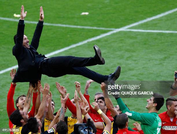 Atletico Madrid's Argentinian coach Diego Simeone is tossed by teammates as they celebrate their Spanish league title at the end of the Spanish...