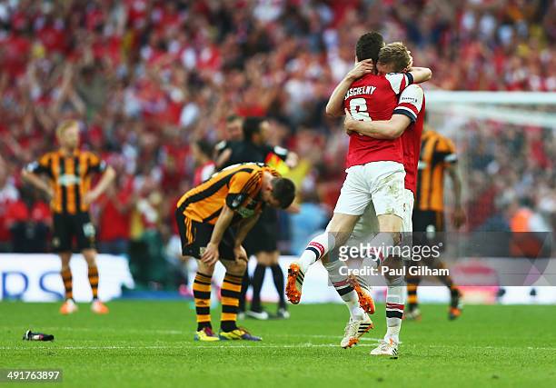 Despair for Hull City as Laurent Koscielny and Per Mertesacker of Arsenal celebrate victory after the FA Cup with Budweiser Final match between...