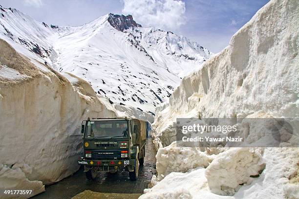 An Indian army truck passes through the snow-cleared Srinagar-Leh highway after it was reopened by authorities on May 17, 2014 in Zojila, 108 km east...