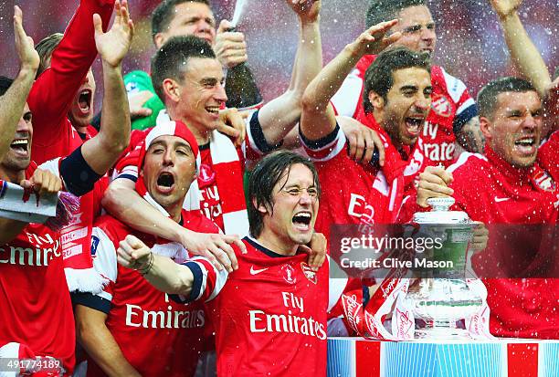 Tomas Rosicky of Arsenal leads the trophy celebrations after the FA Cup with Budweiser Final match between Arsenal and Hull City at Wembley Stadium...