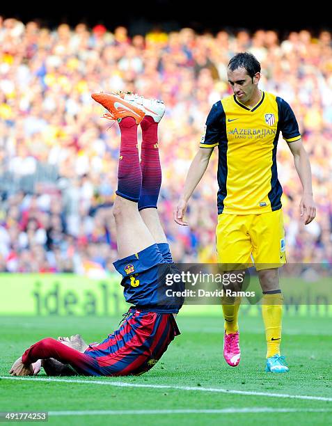 Diego Godin of Atletico de Madrid looks at Gerard Pique of FC Barcelona as he reacts on the pitch during the La Liga match between FC Barcelona and...