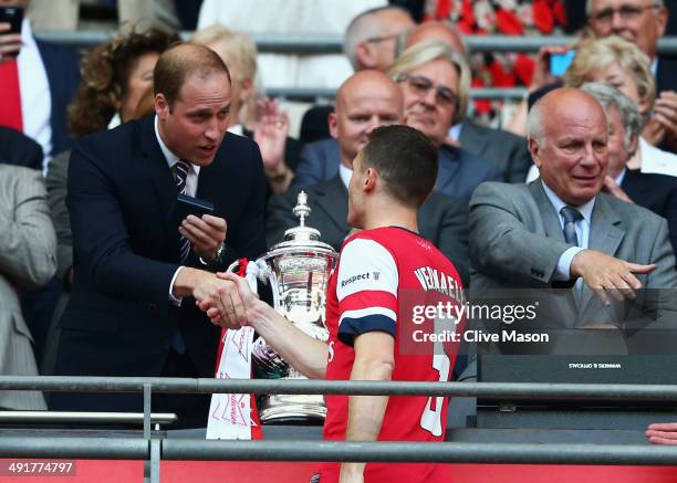 Captain Thomas Vermaelen of Arsenal shakes hands with Prince William, Duke of Cambridge as FA Chairman Greg Dyke looks on after after the FA Cup with...