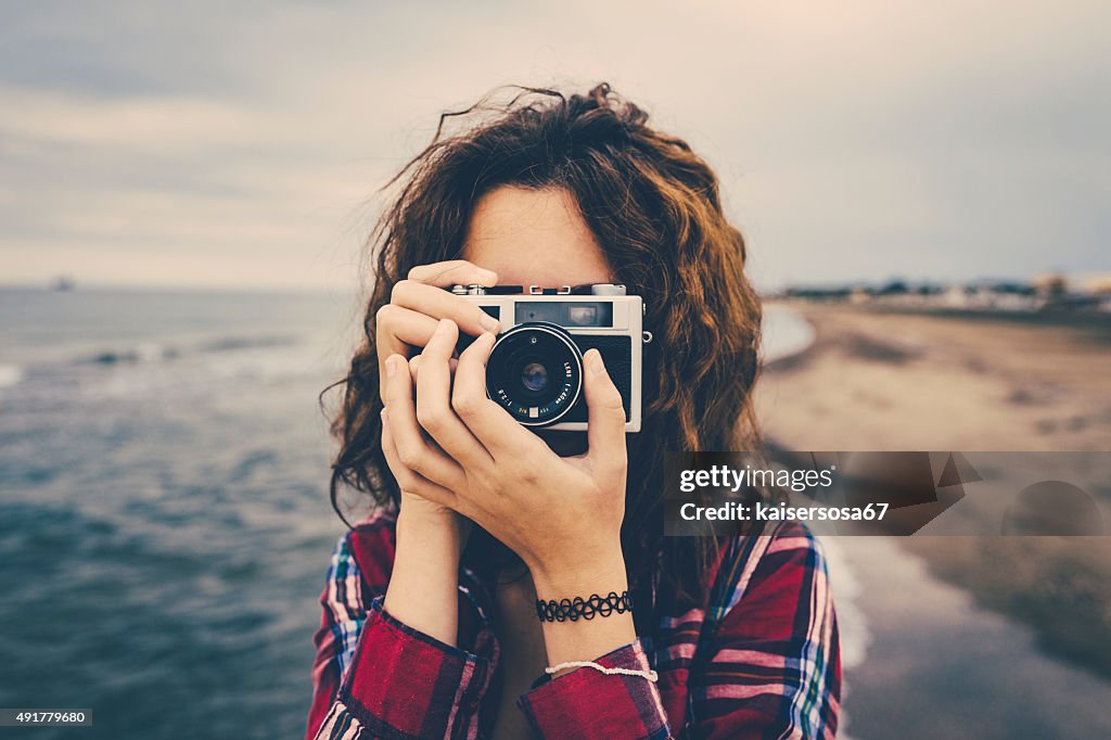 Mädchen nimmt ein Foto am Meer mit einem film-Kamera