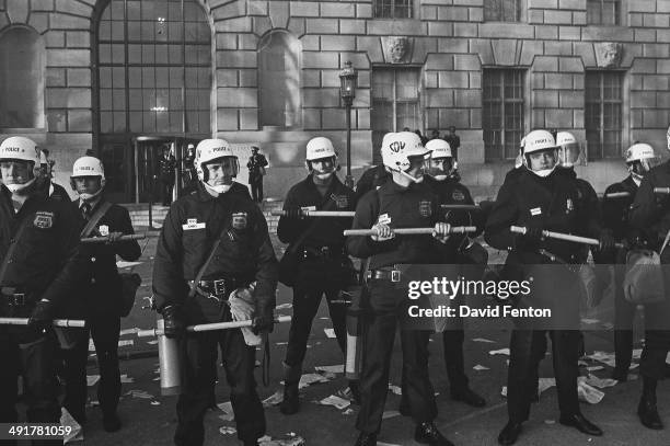 View of a line of Metropolitan Police officers, in CDU helmets, as the holds nightsticks at the ready outside the US Department of Labor biulding ,...