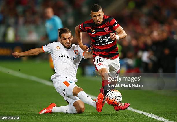 Devante Clut of the Roar and Mark Bridge of the Wanderers contest possession during the round one A-League match between the Western Sydney Wanderers...