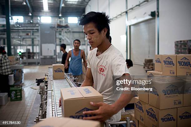 An employee loads cases of Yoma Beer onto a crate on the bottling line at the Myanmar Carlsberg Co. Plant in Nyaung Inn Village, Bago, Myanmar, on...