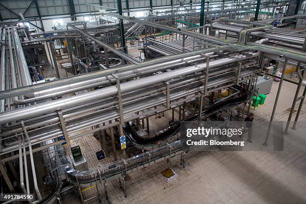 An employee walks past the bottling line at the Myanmar Carlsberg Co. Plant in Nyaung Inn Village, Bago, Myanmar, on Wednesday, Oct. 7, 2015....