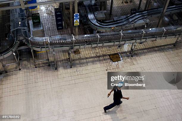 An employee walks past the bottling line at the Myanmar Carlsberg Co. Plant in Nyaung Inn Village, Bago, Myanmar, on Wednesday, Oct. 7, 2015....