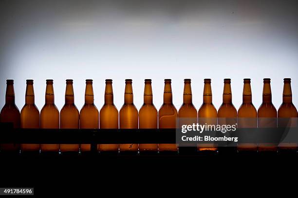 Bottles of beer are illuminated to check volume levels on the bottling line at the Myanmar Carlsberg Co. Plant in Nyaung Inn Village, Bago, Myanmar,...