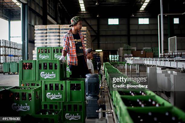 An employee prepares to load empty beer bottles onto the bottling line at the Myanmar Carlsberg Co. Plant in Nyaung Inn Village, Bago, Myanmar, on...