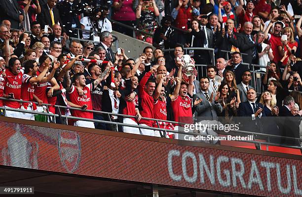 Captain Thomas Vermaelen of Arsenal lifts the trophy in celebration alongside team mates after the FA Cup with Budweiser Final match between Arsenal...