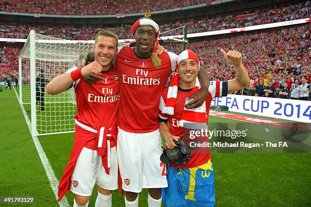 Lukas Podolski, Yaya Sanogo and Santi Cazorla of Arsenal celebrate after the FA Cup with Budweiser Final match between Arsenal and Hull City at...