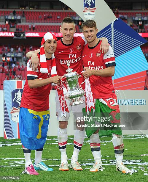 Arsenal's Santi Cazorla, Laurent Koscielny and Aaron Ramsey with the FA Cup after the FA Cup Final between Arsenal and Hull City at Wembley Stadium...