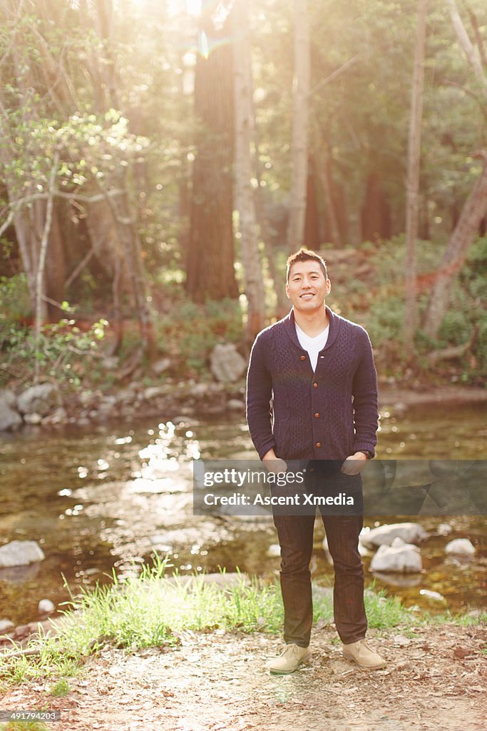 Portrait of Asian man in forest setting, stream
