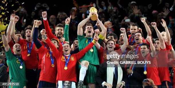 Spain's goalkeeper Iker Casillas raises the trophy handed to him by FIFA President Sepp Blatter and South Africa's President Jacob Zuma as Spain's...