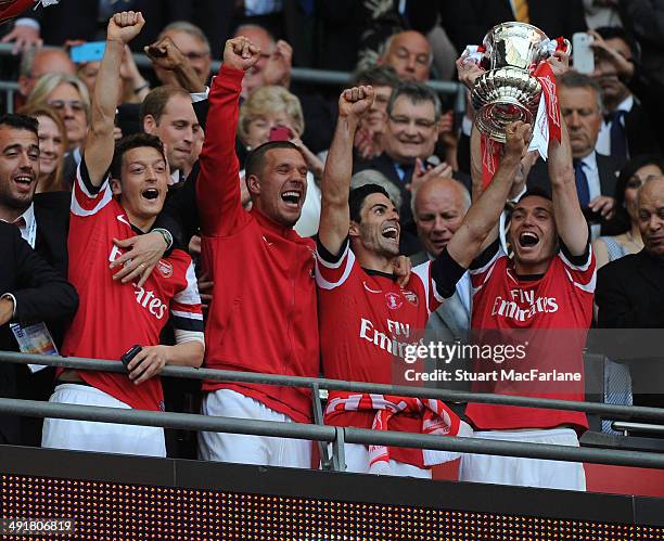 Mesut Ozil, Lukas Podolski, Mikel Arteta and Thomas Vermaelen lift the FA Cup after the FA Cup Final between Arsenal and Hull City at Wembley Stadium...