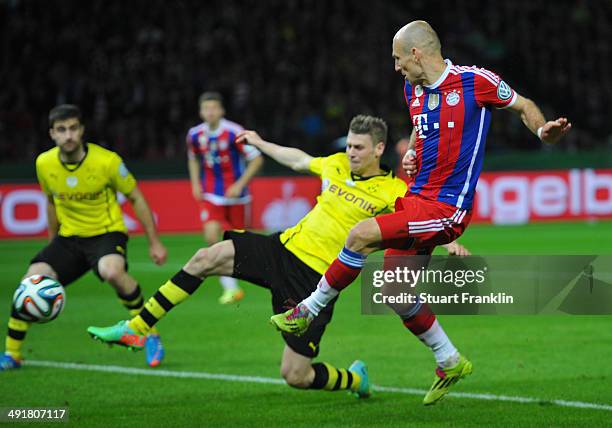 Arjen Robben of Bayern Muenchen scores his team's first goal against Lukasz Piszczek of Borussia Dortmund during the DFB Cup Final match between...