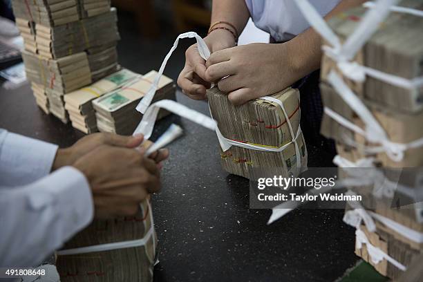 Bank empoyees bundle deposited kyat at the KBZ Bank main office on October 8, 2015 in Yangon, Burma. In Burma, the most widely deposited bank note is...