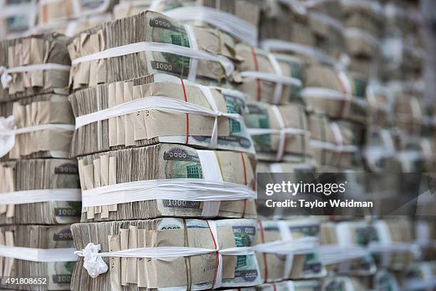 Kyat notes sit in a pile at the KBZ Bank main office on October 8, 2015 in Yangon, Burma. In Burma, the most widely deposited bank note is worth...