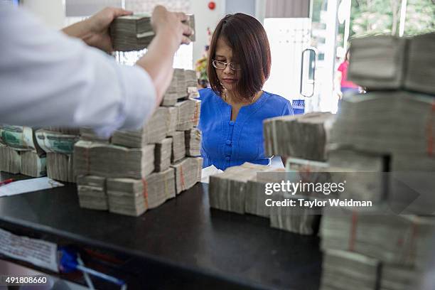 Customer makes a deposit at the KBZ Bank main office on October 8, 2015 in Yangon, Burma. In Burma, the most widely deposited bank note is worth...
