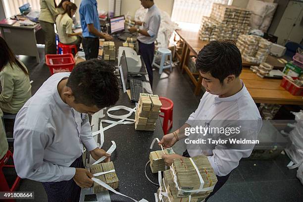 Bank employees bundle deposited kyat at the KBZ Bank main office on October 8, 2015 in Yangon, Burma. In Burma, the most widely deposited bank note...