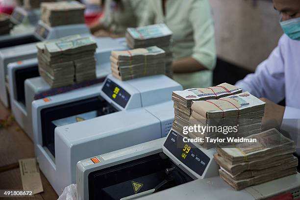 Kyat are counted after a deposit at the KBZ Bank main office on October 8, 2015 in Yangon, Burma. In Burma, the most widely deposited bank note is...