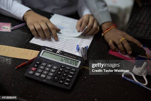 Calculations are made for a customer's withdrawal at the KBZ Bank main office on October 8, 2015 in Yangon, Burma. In Burma, the most widely...