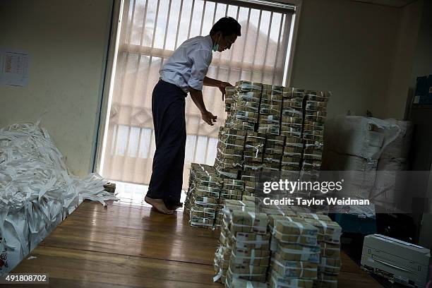 Bank employee stacks 1,000 kyat notes at the KBZ Bank main office on October 8, 2015 in Yangon, Burma. In Burma, the most widely deposited bank note...