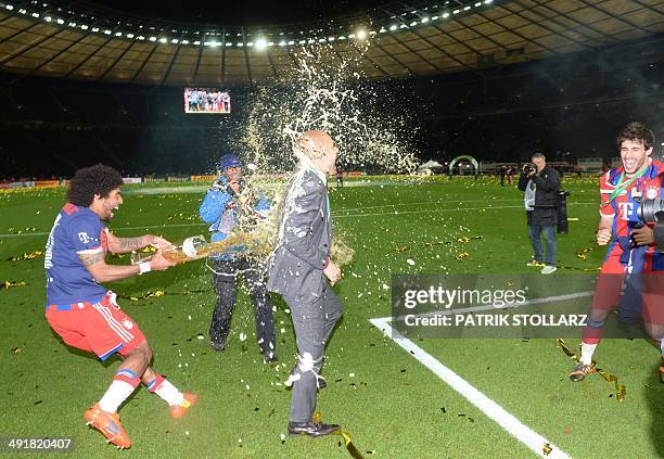 Bayern Munich's Spanish head coach Pep Guardiola has beer poured over him by Brazilian defender Dante after the DFB German Cup final football match...